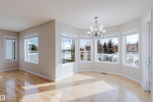 This bright living area features light hardwood flooring and numerous windows, providing ample natural light - 1135 112 Street, Edmonton, AB - Indoor Photo Showing Other Room