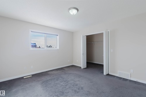 This room features light-colored walls and dark carpeting, with a window providing natural light - 1135 112 Street, Edmonton, AB - Indoor Photo Showing Other Room