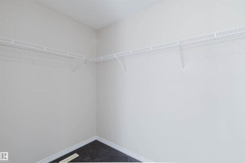 This closet features white wire shelving providing storage space and dark flooring - 1135 112 Street, Edmonton, AB - Indoor With Storage