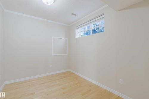 This room features light-colored walls, light-toned wood flooring, and a window providing natural light - 1135 112 Street, Edmonton, AB - Indoor Photo Showing Other Room