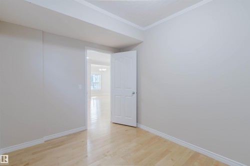 This room features light-colored hardwood flooring, white baseboards, and a white interior door - 1135 112 Street, Edmonton, AB - Indoor Photo Showing Other Room
