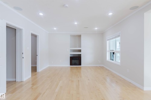 Bright room featuring hardwood floors, recessed lighting, and a built-in fireplace - 1135 112 Street, Edmonton, AB - Indoor With Fireplace