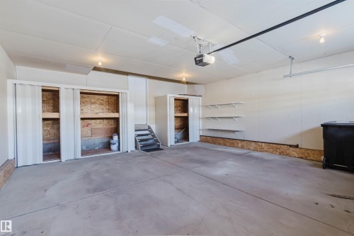 The property features an extensive garage with a concrete floor, built-in shelving, and dedicated storage units - 1135 112 Street, Edmonton, AB - Indoor Photo Showing Garage