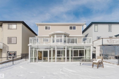 The property features a sunroom with extensive glass paneling, a balcony with glass railings, and an octagonal bay window on the upper level - 1135 112 Street, Edmonton, AB - Outdoor With Exterior