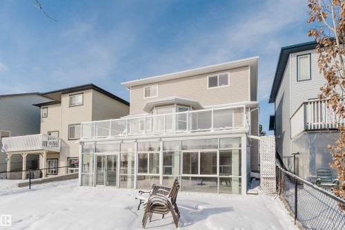 The property features a sunroom with large windows and a glass railing balcony above - 1135 112 Street, Edmonton, AB - Outdoor