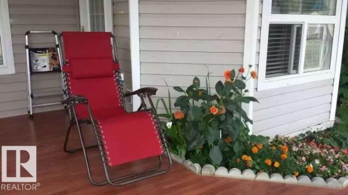 Inviting outdoor porch space with wood flooring and light gray siding - 1135 112 Street, Edmonton, AB - Outdoor With Exterior