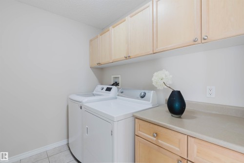 Utility area featuring overhead and base cabinetry, a countertop, and tile flooring - 1135 112 Street, Edmonton, AB - Indoor Photo Showing Laundry Room