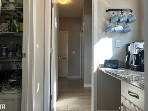 Kitchen area featuring a granite-style countertop, light grey cabinetry, and a coffee station - 5333 21A Avenue, Edmonton, AB - Indoor Photo Showing Other Room