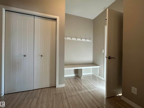 Entryway featuring light-toned walls, tile flooring, a built-in bench, and a coat rack - 5333 21A Avenue, Edmonton, AB - Indoor Photo Showing Other Room
