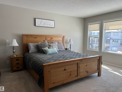 Bedroom featuring two windows providing natural light, light-colored walls, and carpeting - 5333 21A Avenue, Edmonton, AB - Indoor Photo Showing Bedroom