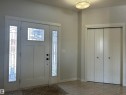 Entryway featuring a white door with decorative glass inserts, side windows with matching decorative glass, and a bi-fold closet with round knobs - 5333 21A Avenue, Edmonton, AB  - Indoor Photo Showing Other Room 