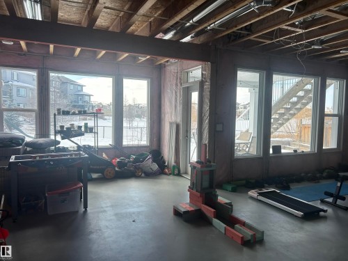 The property features expansive windows offering abundant natural light and views of the surrounding outdoor environment - 5333 21A Avenue, Edmonton, AB - Indoor Photo Showing Gym Room