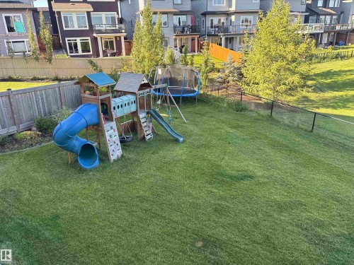 The property features an extensive, well-maintained lawn, bordered by a wooden fence along one side and a chain-link fence on another - 5333 21A Avenue, Edmonton, AB - Outdoor