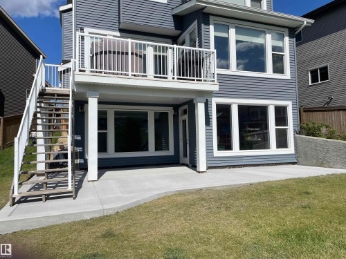 The property features a spacious rear patio and a second-story balcony with white railings, offering outdoor living options - 5333 21A Avenue, Edmonton, AB - Outdoor
