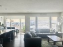 The spacious living area features large windows providing ample natural light, a dark wood floor, and a rug with a geometric pattern - 5333 21A Avenue, Edmonton, AB  - Indoor Photo Showing Living Room 