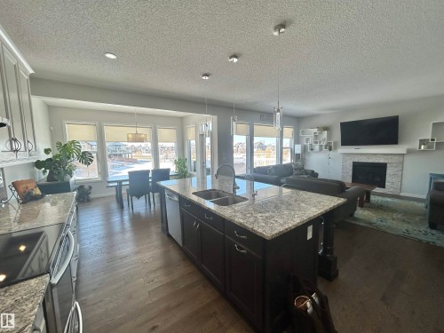 Open concept living area featuring hardwood flooring throughout - 5333 21A Avenue, Edmonton, AB - Indoor Photo Showing Other Room With Fireplace