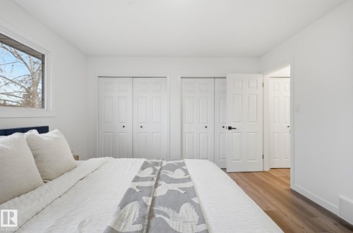 Bedroom with light wood-type flooring and two closets - 2722 104A Street, Edmonton, AB - Indoor Photo Showing Bedroom