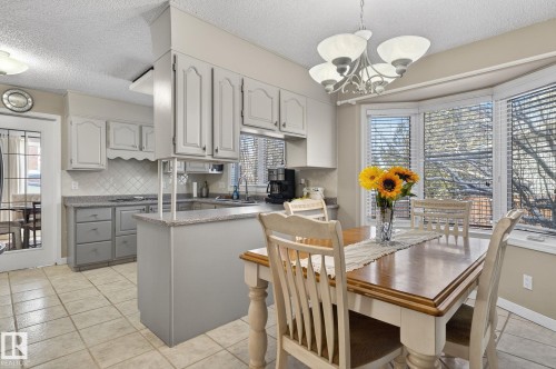 The kitchen features light-colored cabinetry, a tile backsplash, and light-colored countertops - 5604 174 Street, Edmonton, AB - Indoor Photo Showing Other Room