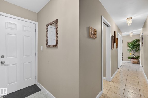 Entryway with a white paneled door, neutral-toned walls, and tile flooring that extends into the hallway - 5604 174 Street, Edmonton, AB - Indoor Photo Showing Other Room