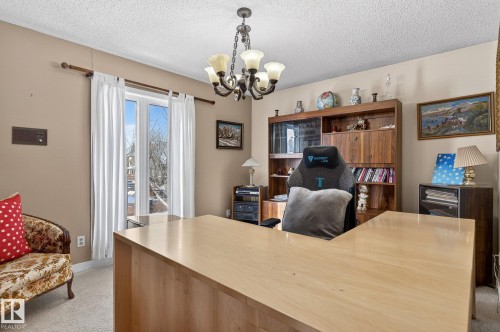 This room features a double window with white curtains, a chandelier, and light-colored carpeting - 5604 174 Street, Edmonton, AB - Indoor