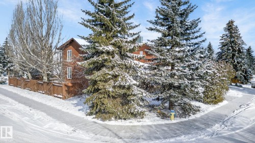 The property features a two-story exterior with a brown facade and white-framed windows, surrounded by a wooden fence - 5604 174 Street, Edmonton, AB - Outdoor