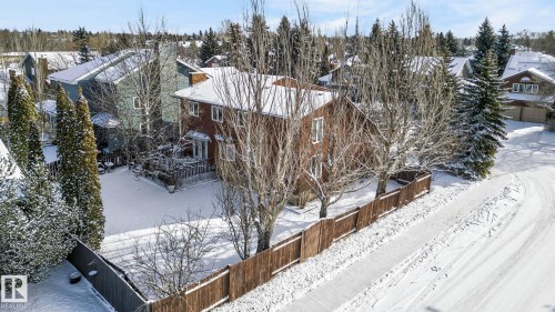 The property features a two-story exterior with a deck, surrounded by mature trees - 5604 174 Street, Edmonton, AB - Outdoor