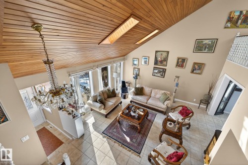 The living area features a high vaulted ceiling with wood paneling and skylights, providing natural light - 5604 174 Street, Edmonton, AB - Indoor
