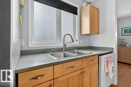 Kitchen with a double basin stainless steel sink, light wood cabinetry, and a countertop - 2655 89 Street, Edmonton, AB - Indoor Photo Showing Kitchen With Double Sink