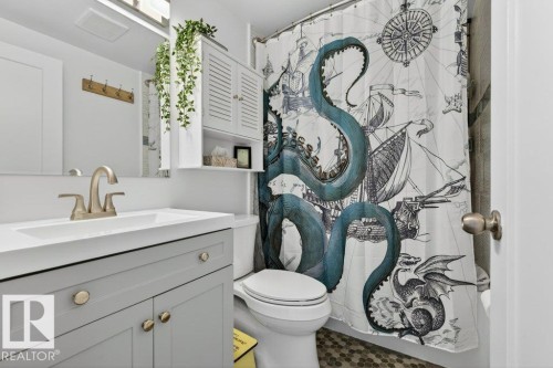 The bathroom features a vanity with a white countertop and a brushed nickel faucet - 2655 89 Street, Edmonton, AB - Indoor Photo Showing Bathroom