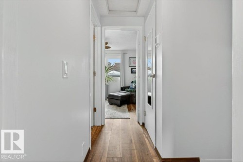 Hallway with light wood flooring and white walls, leading to a room with a window providing natural light - 2655 89 Street, Edmonton, AB - Indoor Photo Showing Other Room