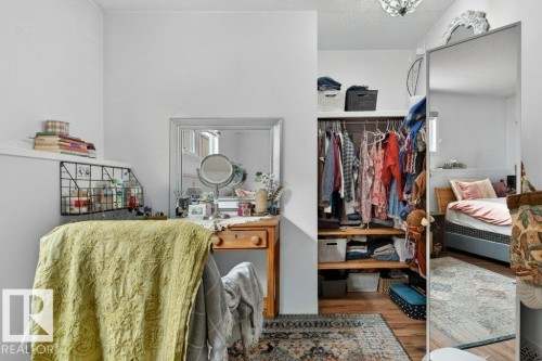 This bedroom features a closet with shelving and hanging space, hardwood flooring, and a mirrored wardrobe - 2655 89 Street, Edmonton, AB - Indoor
