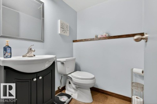 Bathroom featuring a vanity with a white basin and a silver-framed mirror - 2655 89 Street, Edmonton, AB - Indoor Photo Showing Bathroom