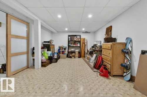 The property features a large room with patterned tile flooring, white walls, and recessed lighting - 2655 89 Street, Edmonton, AB - Indoor