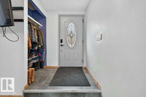 The property features an entryway with tiled flooring, a decorative front door with an oval glass insert, and a coat and shoe storage area - 2655 89 Street, Edmonton, AB - Indoor Photo Showing Other Room
