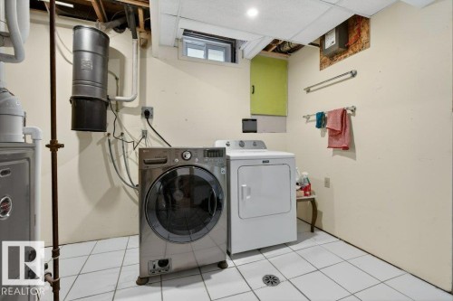 Laundry area with a front-loading washing machine, a dryer, and tiled flooring - 2655 89 Street, Edmonton, AB - Indoor Photo Showing Laundry Room