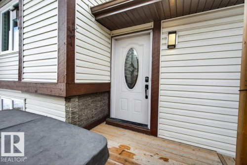 The property features white horizontal siding with dark wood trim accents - 2655 89 Street, Edmonton, AB - Outdoor With Exterior