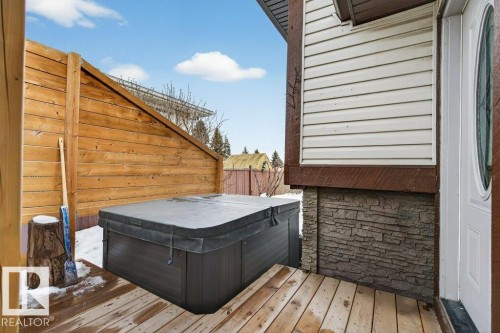 The property features a private outdoor area with a hot tub, a wooden deck, and a privacy fence - 2655 89 Street, Edmonton, AB - Outdoor With Deck Patio Veranda With Exterior