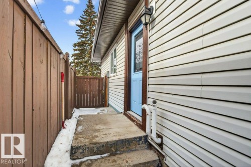 The property features light blue exterior door with a window and an overhead light fixture - 2655 89 Street, Edmonton, AB - Outdoor