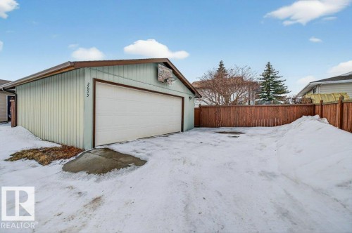 Detached garage with a white overhead door and a brown privacy fence - 2655 89 Street, Edmonton, AB - Outdoor With Exterior