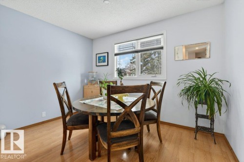 This room features hardwood floors and a window with blinds, allowing for natural light - 2655 89 Street, Edmonton, AB - Indoor Photo Showing Dining Room