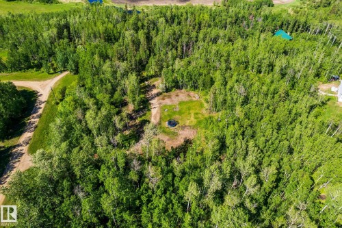 Expansive wooded property featuring a cleared central area, a visible round trampoline, and a network of unpaved paths - 17 56110 Rge Road 13, Rural Lac Ste. Anne County, AB 