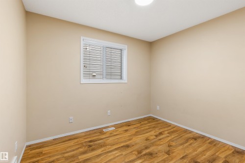 This room features light-colored walls, wood-style flooring, and a window with blinds - 1233 Ormsby Lane, Edmonton, AB - Indoor Photo Showing Other Room