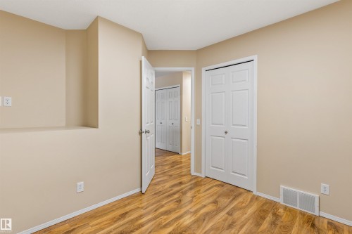 This interior space features light beige walls, wood-style flooring, and white trim - 1233 Ormsby Lane, Edmonton, AB - Indoor Photo Showing Other Room