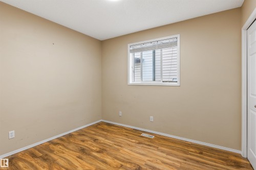 The room features hardwood style flooring, a window with blinds, and light-colored walls - 1233 Ormsby Lane, Edmonton, AB - Indoor Photo Showing Other Room