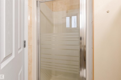 Bathroom featuring a shower with a glass enclosure and tiled walls - 1233 Ormsby Lane, Edmonton, AB - Indoor Photo Showing Bathroom