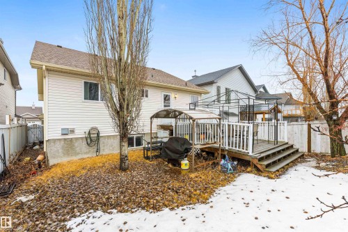 The property features a rear exterior with horizontal siding, a multi-level deck with white railings, and a fenced yard - 1233 Ormsby Lane, Edmonton, AB - Outdoor With Deck Patio Veranda