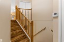 Staircase featuring wooden steps and railings, with a wall-mounted control panel visible - 1233 Ormsby Lane, Edmonton, AB  - Indoor Photo Showing Other Room 