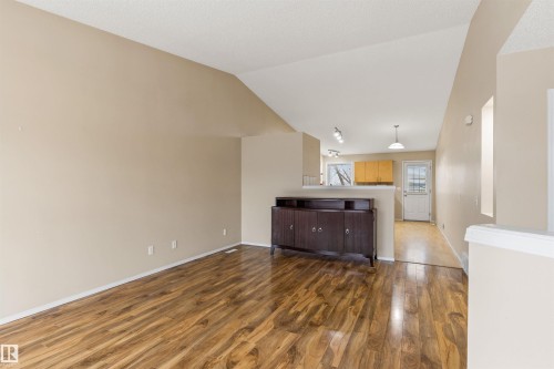 The spacious interior features wood flooring, a neutral color palette, and a vaulted ceiling - 1233 Ormsby Lane, Edmonton, AB - Indoor