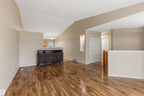 The living area features vaulted ceilings, warm-toned walls, and durable wood-look flooring - 1233 Ormsby Lane, Edmonton, AB - Indoor