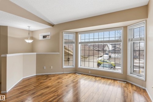 This living area features hardwood floors and a bay window with horizontal blinds - 1233 Ormsby Lane, Edmonton, AB - Indoor Photo Showing Other Room